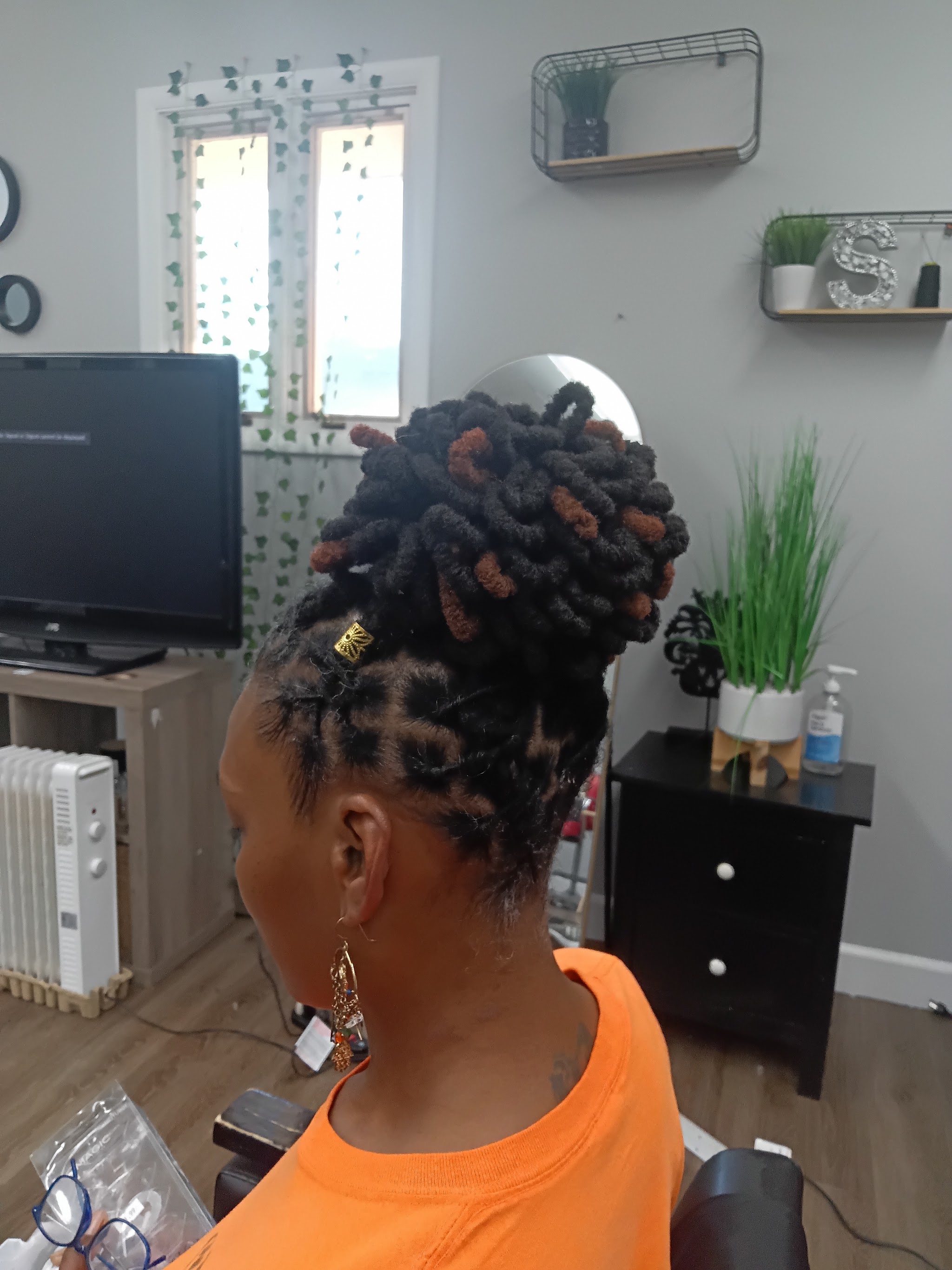 Faux locs updo with copper accents, styled at our salon